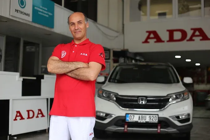 Kırmızı ADA forması giyen teknisyenimiz, arkasında beyaz Honda CR-V ile atölye önünde