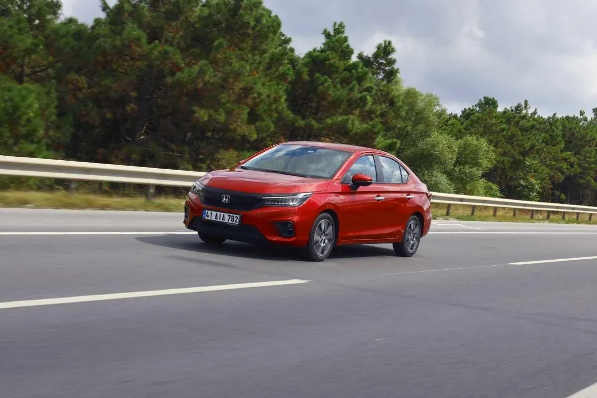 Kırmızı Honda City sedan, yolda hareket hâlinde ön çapraz açıdan çekim, TR plakası görünüyor