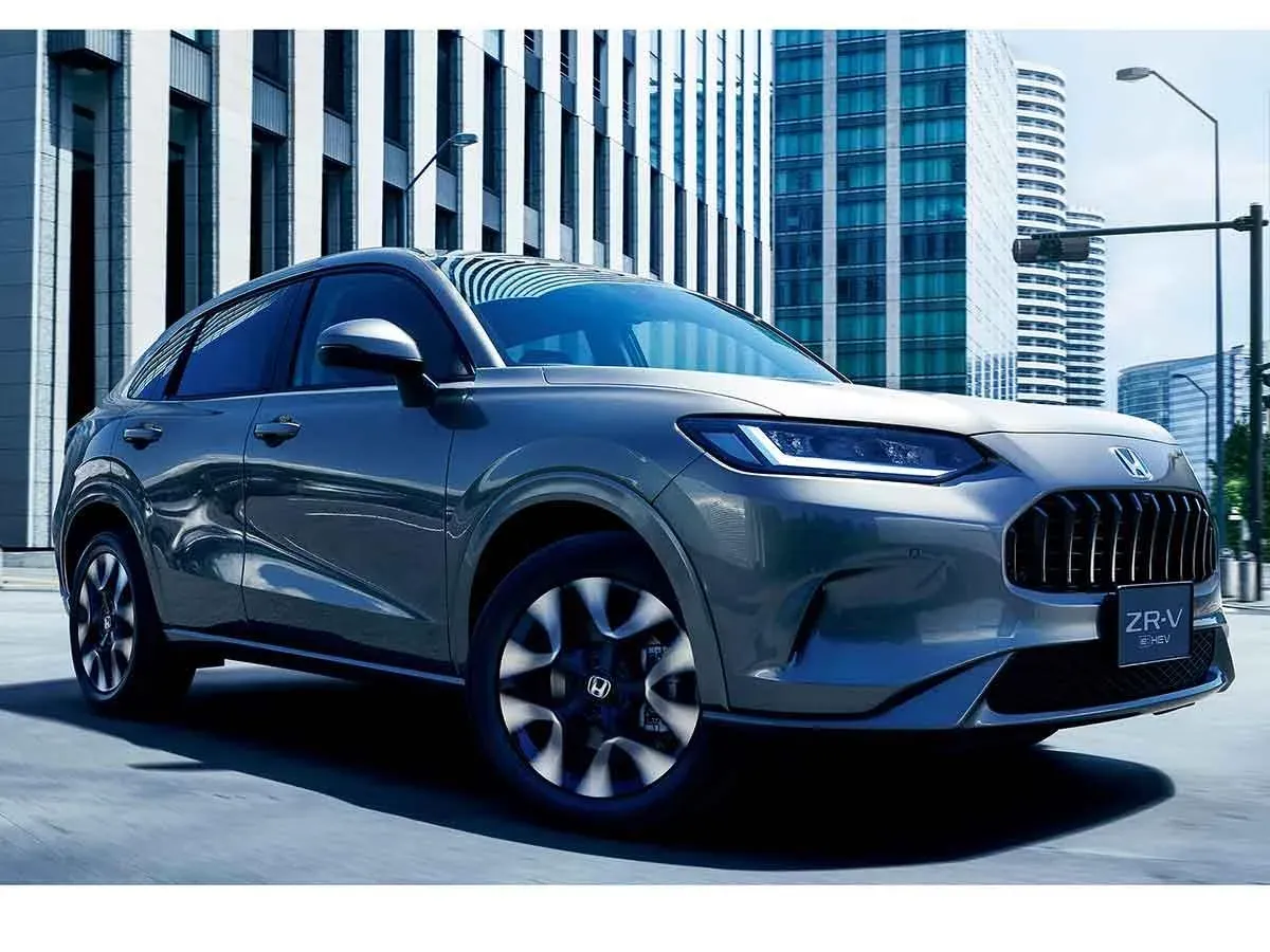 Gri Honda ZR-V crossover, şehir/ofis binaları önünde ön çapraz açı, plakada "ZR-V e:HEV" yazısı net okunuyor